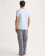 The back view of a man wearing a light blue T-shirt and patterned pants, showcasing a blend of comfort and understated elegance.