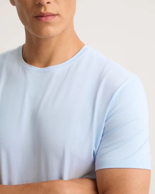 A man dressed in a light blue T-shirt, emphasizing its luxurious comfort and sustainable craftsmanship for everyday wear.