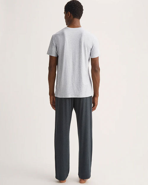 A man faced backwards with a grey shirt and dark grey pants. 