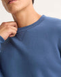 A man dressed in a blue sweatshirt, exuding a laid-back and casual appearance.