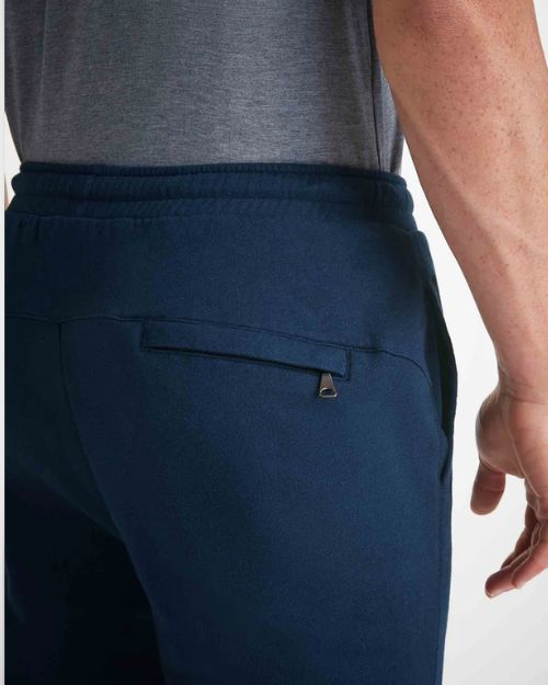 Up-close image of the back zipped pocket on navy-blue joggers.