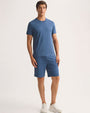 A model showcases a casual outfit featuring a blue t-shirt and shorts, perfect for warm weather.