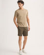 The model is dressed in khaki shorts and a t-shirt, presenting a relaxed and stylish look.
