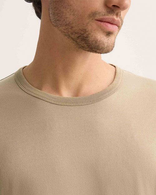 A man wearing a taupe-colored t-shirt.