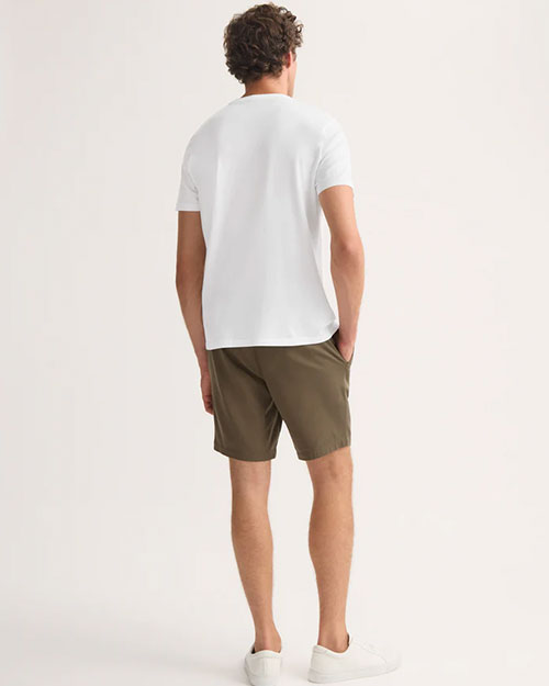 Man's back view wearing shorts and a plain white t-shirt, in a casual setting.