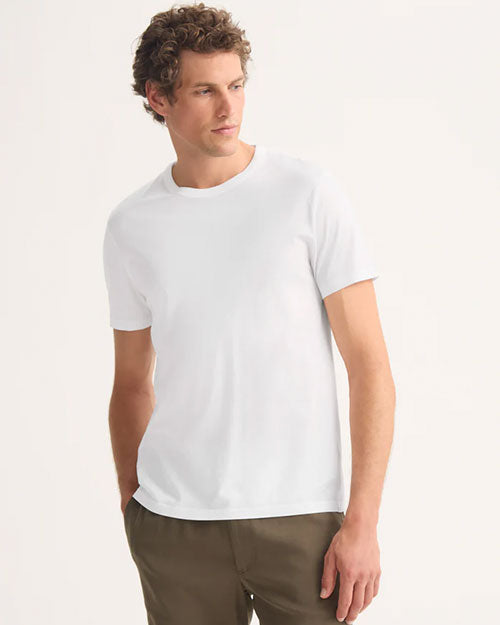  A man wearing a white t-shirt and khaki shorts stands confidently
