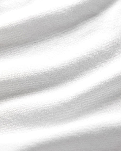 Close-up of a textured white fabric, showcasing its rich color and intricate weave details.