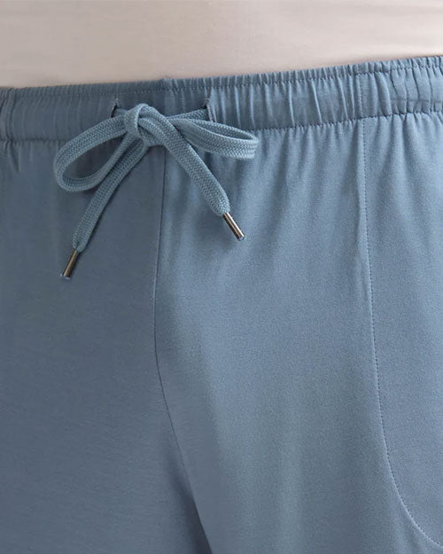 Close-up view of a man dressed in blue shorts, highlighting the color and texture of the material.