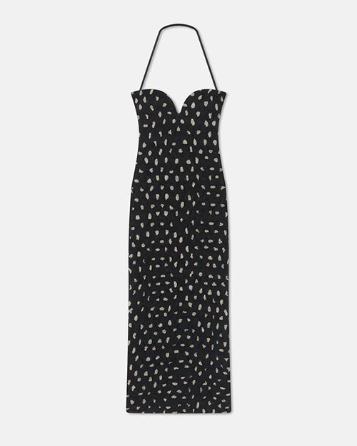 A long, black strapless dress with a sweetheart neckline and a halter neck strap. The dress features an all-over pattern of small, irregular white spots.