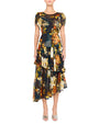 Person wearing a dark floral dress with short sleeves, a round neckline, and an asymmetrical ruffled hemline. The floral pattern features yellow, orange, and green tones. The outfit is paired with open-toed shoes.
