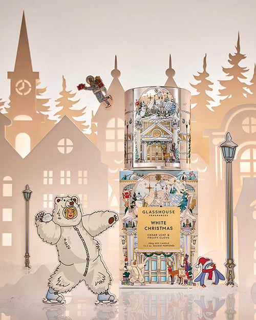 Decorative holiday candle featuring a polar bear and festive Christmas village artwork.