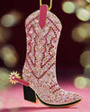 A pink cowboy boot ornament adorned with pink crystals, designed to hang on a Christmas tree.