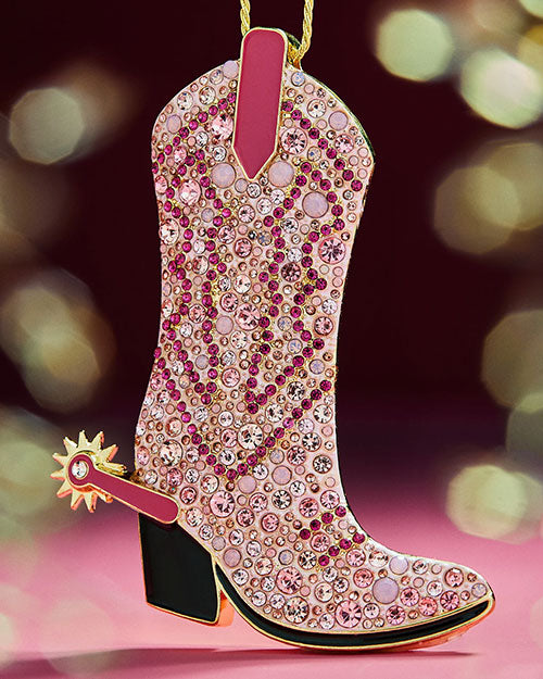 A pink cowboy boot ornament adorned with pink crystals, designed to hang on a Christmas tree.