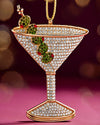 A decorative martini glass ornament adorned with red and green holly leaves, evoking a festive holiday spirit.