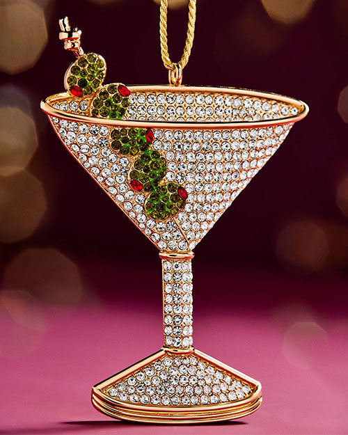A decorative martini glass ornament adorned with red and green holly leaves, evoking a festive holiday spirit.