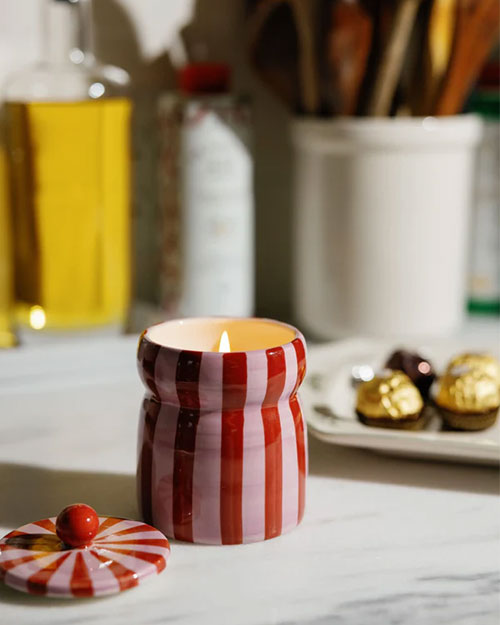 A red and pink striped candle placed on a countertop, adding a decorative touch to the setting.