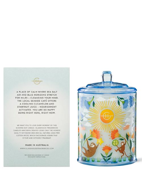 The Glasshouse Fragrance Mocktail Mediation candle features a captivating floral design and charming illustrations of a monkey and sloth on the glass jar and an accompanying card describing the candle.