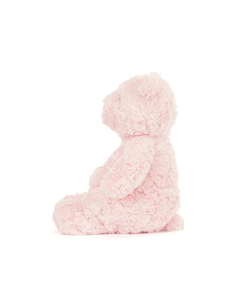 Side view of a fluffy pink bear plush on a white background