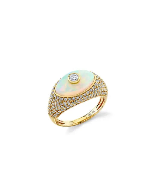A diamond and gold ring, with an iridescent opal center in the shape of an eye, with a large diamond in the center. 