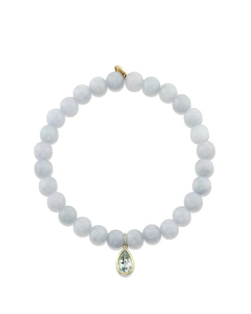 An image of a light blue beaded bracelet with a pear-shaped blue gemstone on a white background. 