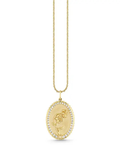Image of a pendant necklace engraved with an image of a flower and outlined in diamonds. 