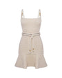 Image of a white mini dress with a rope tied at the waist with gold beads on the straps and ties on a white background. 