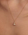 Close-up of a gold necklace featuring a duck-shaped pendant encrusted with small sparkling stones. The thin, delicate chain complements the ornate and playful design of the pendant.