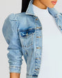 A close-up of a denim jacket, showcasing the texture, stitching, and buttons. Denim jacket worn on a model.