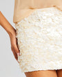 Close up of a sequin beige skirt on a person.