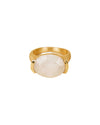 A gold ring featuring a large, oval-shaped white gemstone set in the center, secured by two prongs on either side.