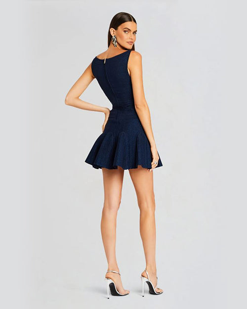 Back view of a person wearing a fit-and-flare style navy dress with silver accessories. Dress has a zip closure.