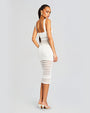 Back view of a model wearing a sleeveless knee length white crochet dress.