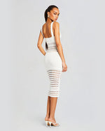 Back view of a model wearing a sleeveless knee length white crochet dress.