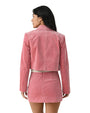 Back view of a person wearing a pink suede jacket and matching pink suede skirt.