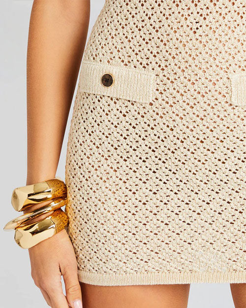 Close up of crochet dress, model wearing gold bangle bracelets to show how to accessorize it.