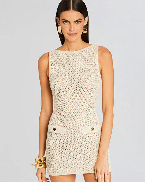 A person modeling a sleeveless, knee-length beige dress with a textured pattern. Image only shows the top part of the model to show the texture of the dress.