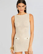 A person modeling a sleeveless, knee-length beige dress with a textured pattern. Image only shows the top part of the model to show the texture of the dress.