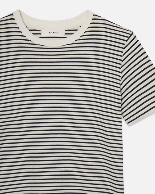 A closeup frontal view of a short-sleeved, crew-neck t-shirt with horizontal black and white stripes. The stripes are evenly spaced and run across the entire shirt, including the sleeves. The neckline is solid white, contrasting with the striped pattern of the rest of the shirt. The background is plain white.