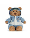 Plush teddy bear wearing a light blue and white winter outfit with a hooded jacket, embroidered orange and black helicopter logo on the chest, matching pants, and green goggles on its head.