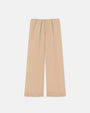 Long beige flowy pants against a white background. The pants have buttons around the outside of the leg holes.