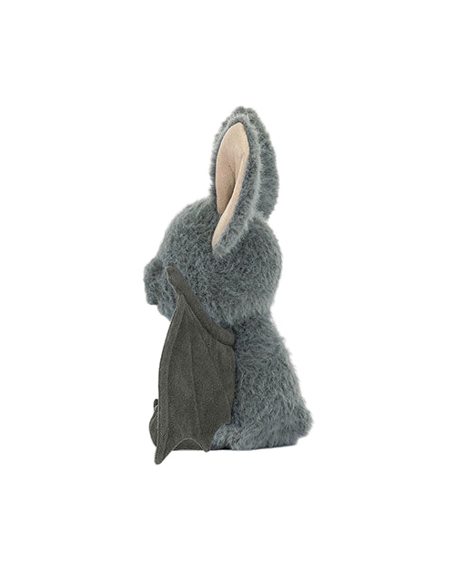 Side view of a grey plush bat toy with large light-colored inner ears and dark grey wings.