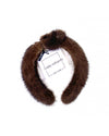 A brown mink fur headband with a knot in the middle. The label has black text that reads “linda richards NEW YORK.” 