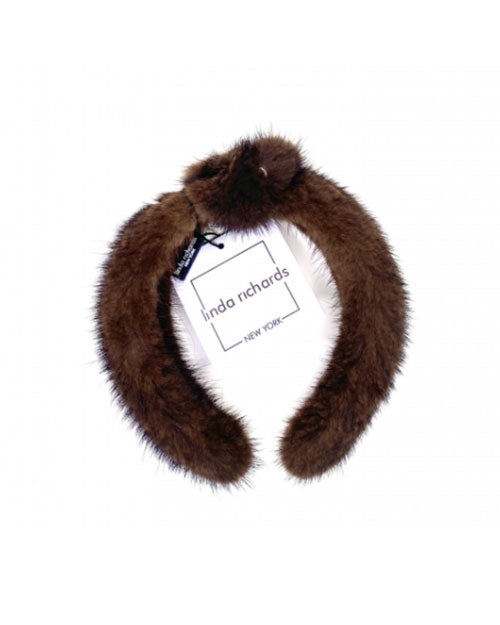 A brown mink fur headband with a knot in the middle. The label has black text that reads “linda richards NEW YORK.” 