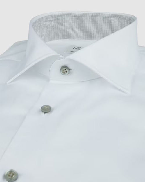 A close-up of a white dress shirt with grey buttons down the front, and a dotted pattern on the inner neckline. The background is white.