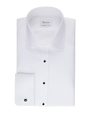 An overhead view of a folded white dress shirt with black buttons down the front and on the chest pocket. There is a white rectangular tag on the inner neckline. The background is plain.