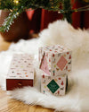 A trio of Christmas card boxes placed on a plush white fur rug, enhancing the seasonal decor.
