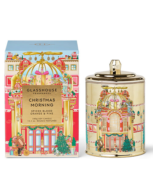 Decorative candle and packaging with festive design on a white background