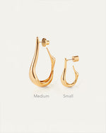 Gold hoop earrings, one medium and one small to show difference in size, on a light gray background