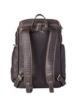 the back of a dark brown leather backpack. The visible grain texture adds to its appeal. The backpack features a large main compartment with a zipper closure, flanked by two vertical zipper pockets on the front side. It has a sturdy top handle and two adjustable shoulder straps attached to the back. 