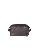 A brown leather dopp kit with a zipper closure and side strap loops, placed against a light grey background. The kit appears cylindrical with a flat base, featuring visible stitching and reinforced corners.